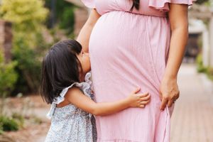 Mother and daughter in matching pink and floral outfits walking together on a path.
