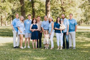 Extended family group photo in coordinated blue and white outfits outdoors.