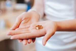Close-up shots of hands displaying delicate wedding day preparations.