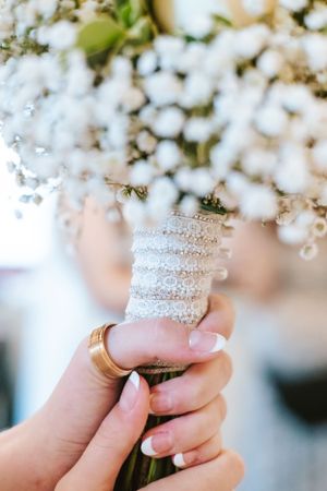 Crystal-wrapped bouquet stem details with white flowers in soft focus background.
