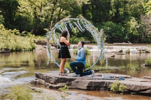 People playing near water fountain splashes in sunny park setting.