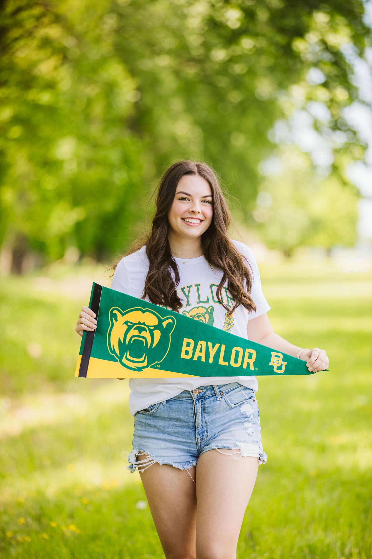 senior session of girl holding a pennant of baylor university