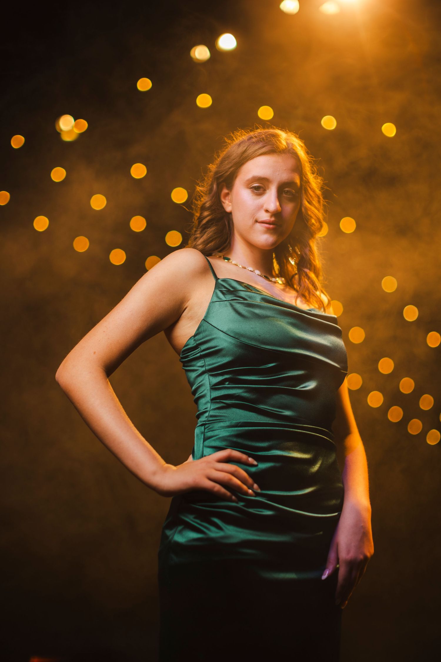 Senior session in formal green dress with lights and haze