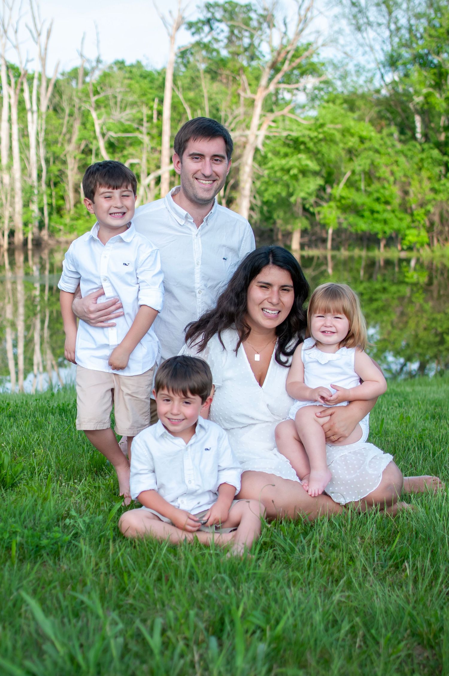 Family sitting pose outdoor near pond
