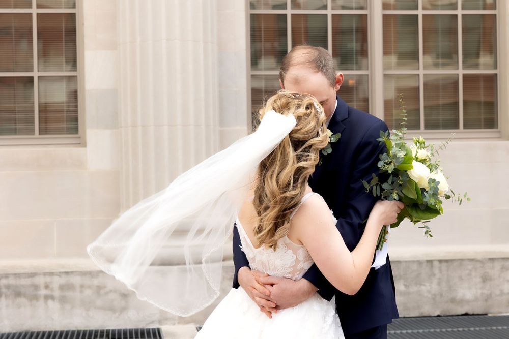 Romantic wedding couple embracing outside historic building.