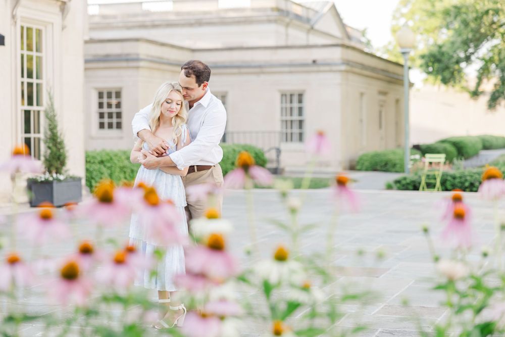 A romantic portrait with wildflowers in the foreground and classic architecture behind.