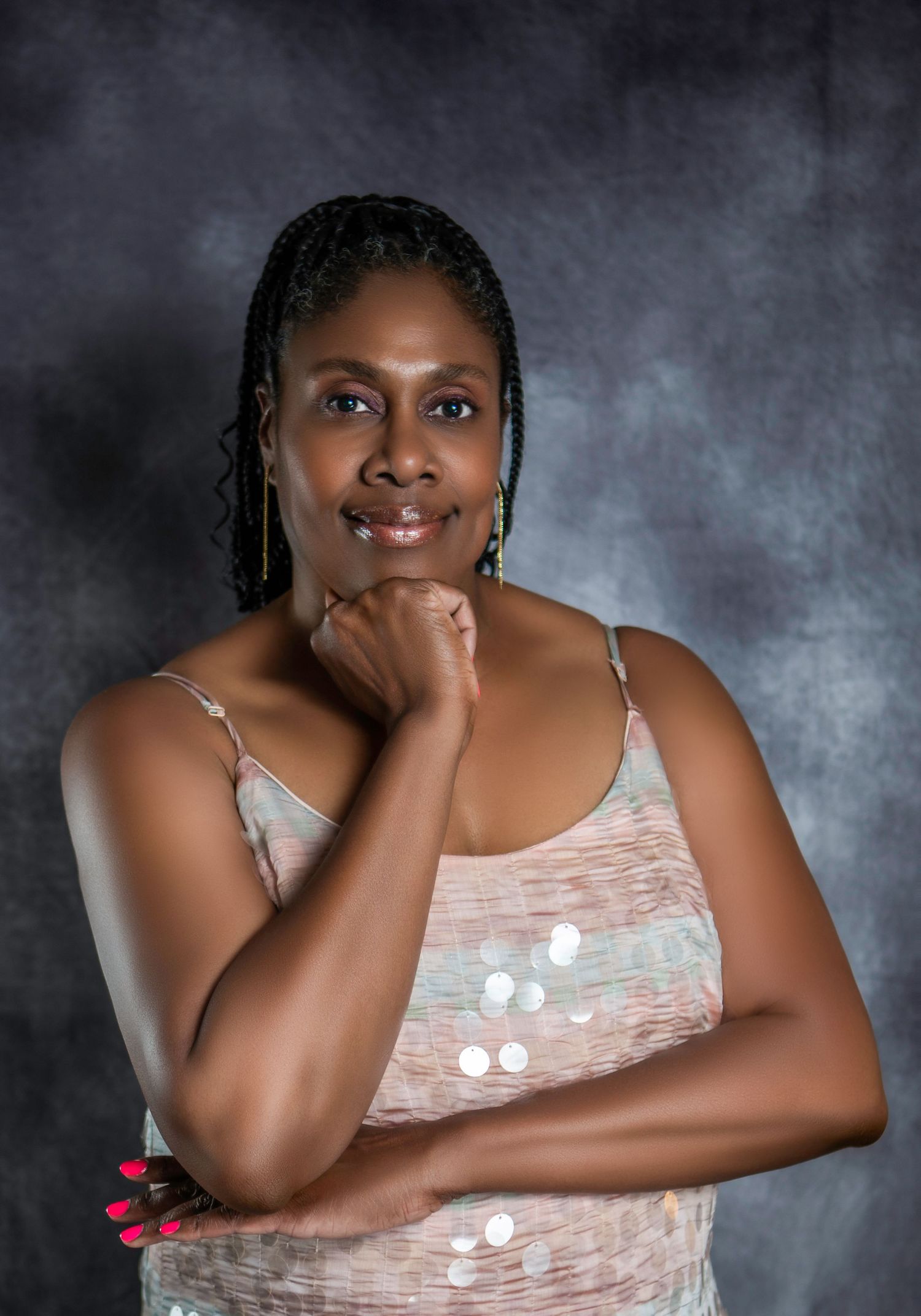 Studio portrait series featuring someone in a light patterned top against textured gray background. Headshot photography