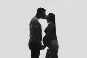 Silhouette of couple sharing intimate moment during maternity photoshoot.