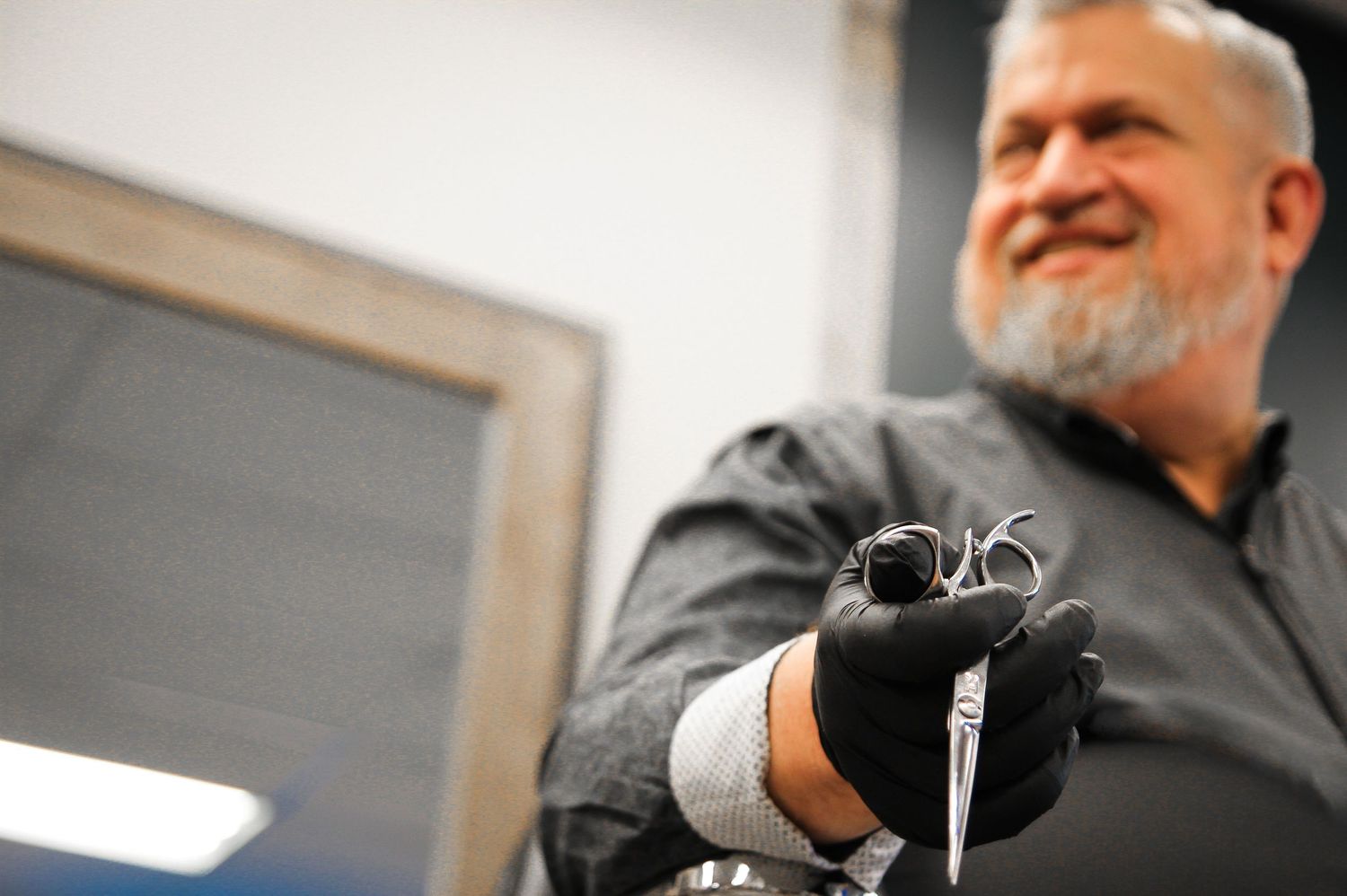 Close-up shot of hands holding tattoo equipment in professional studio setting.