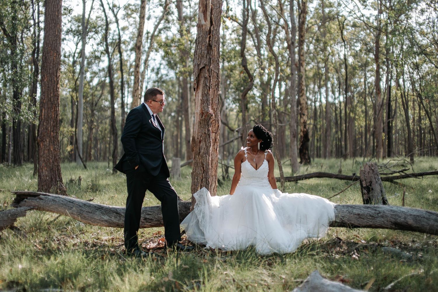 A couple poses in a gothic stone archway during their wedding photoshoot.