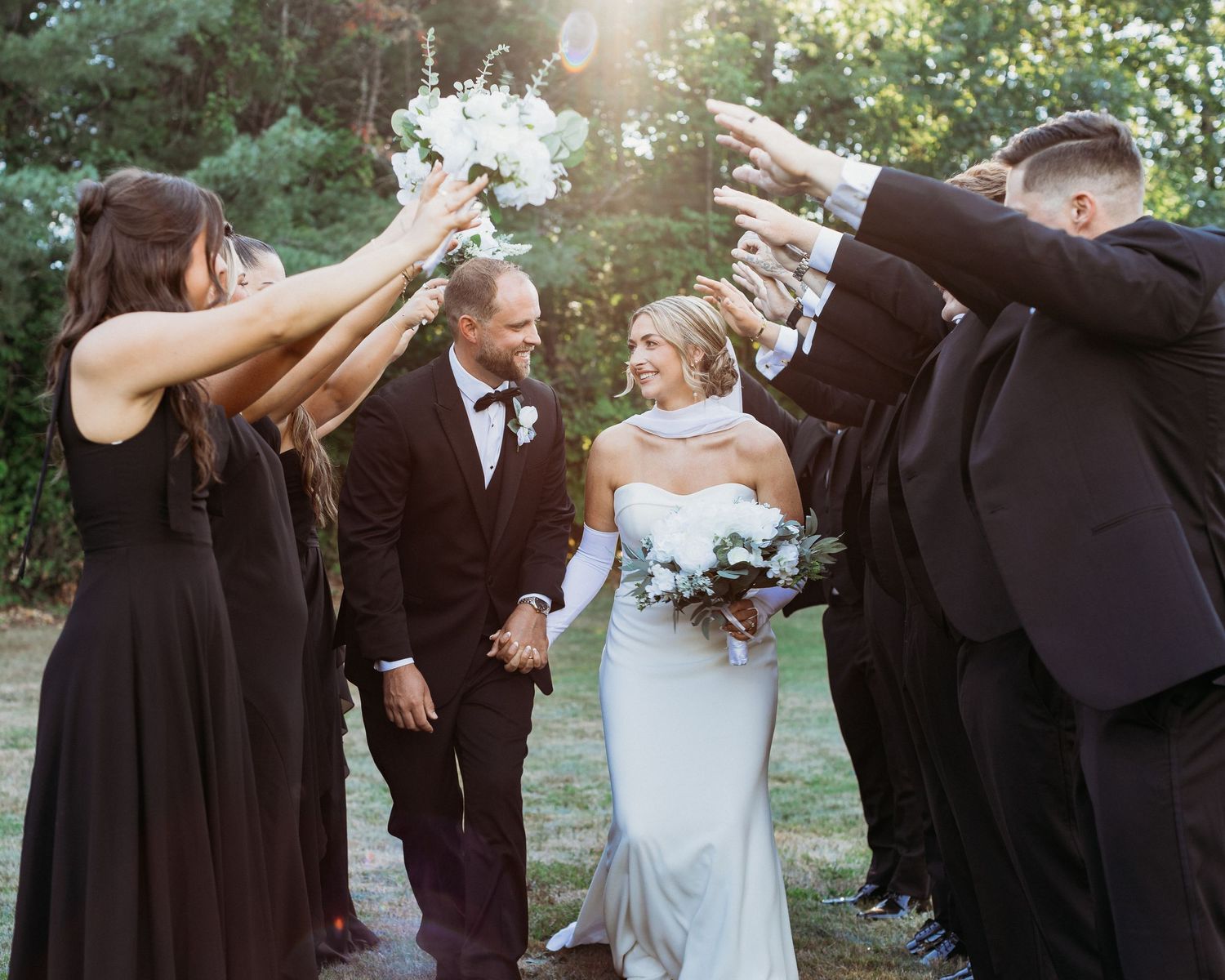 bride and groom running through a bridal party tunnel celebrating their marriage