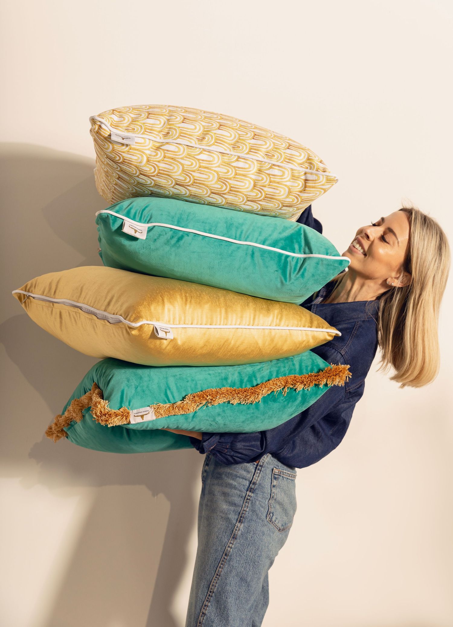 Person in denim jeans and navy top demonstrating the progression of a pillow falling in a sequence of photos.