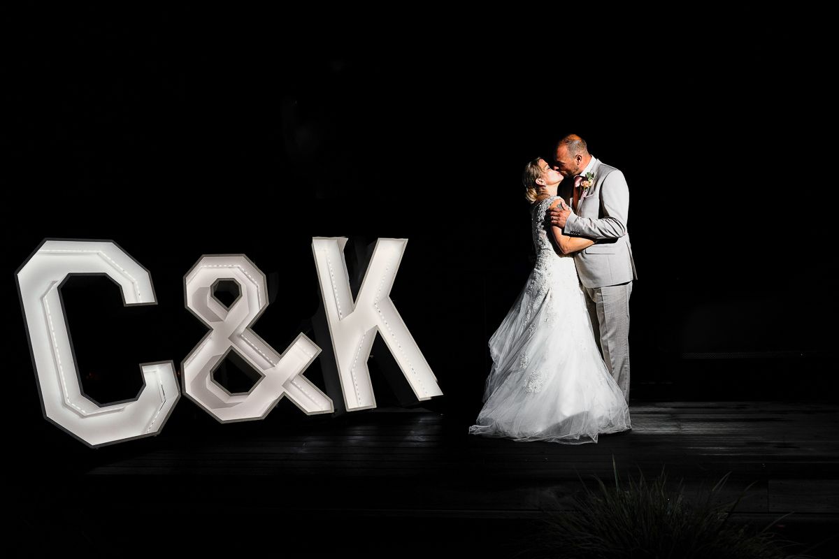 Intimate dance moment captured at wedding reception under warm atmospheric lighting.