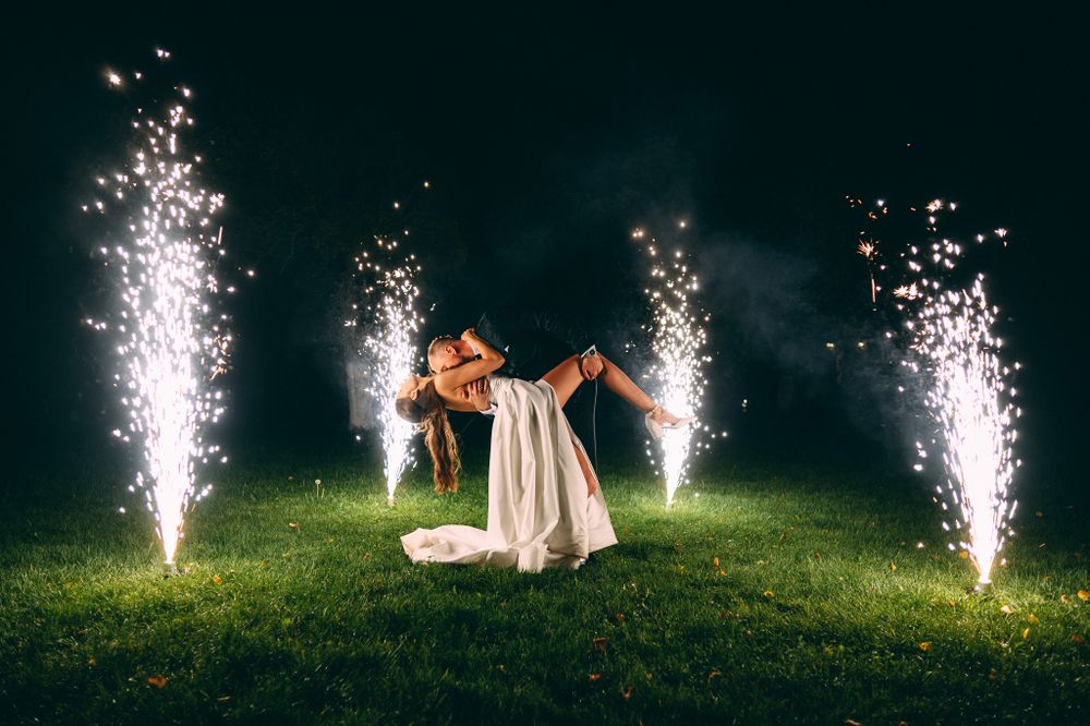 Nighttime celebration with sparklers creating bright light trails against dark background.
