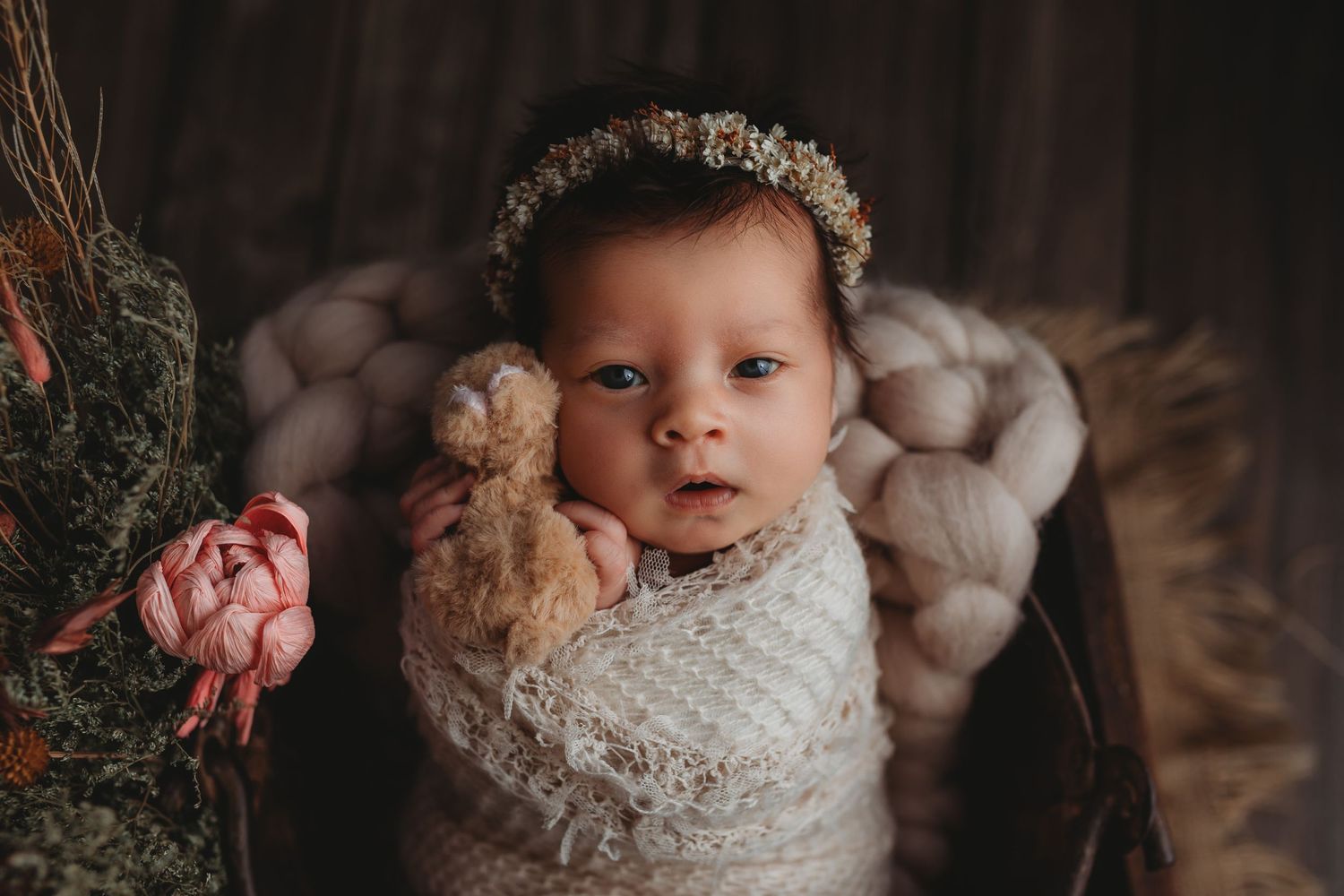 Delicate newborn photography featuring soft textures and neutral tones in a studio setting.