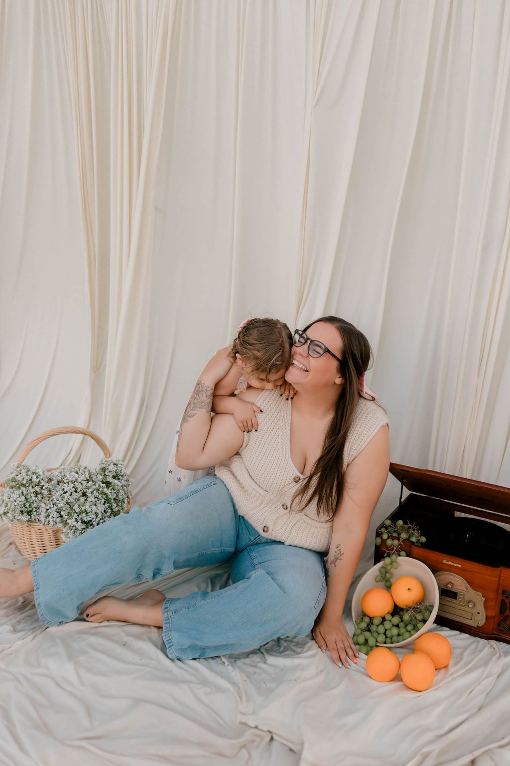 Cozy indoor picnic scene with fruit basket and white drape backdrop.