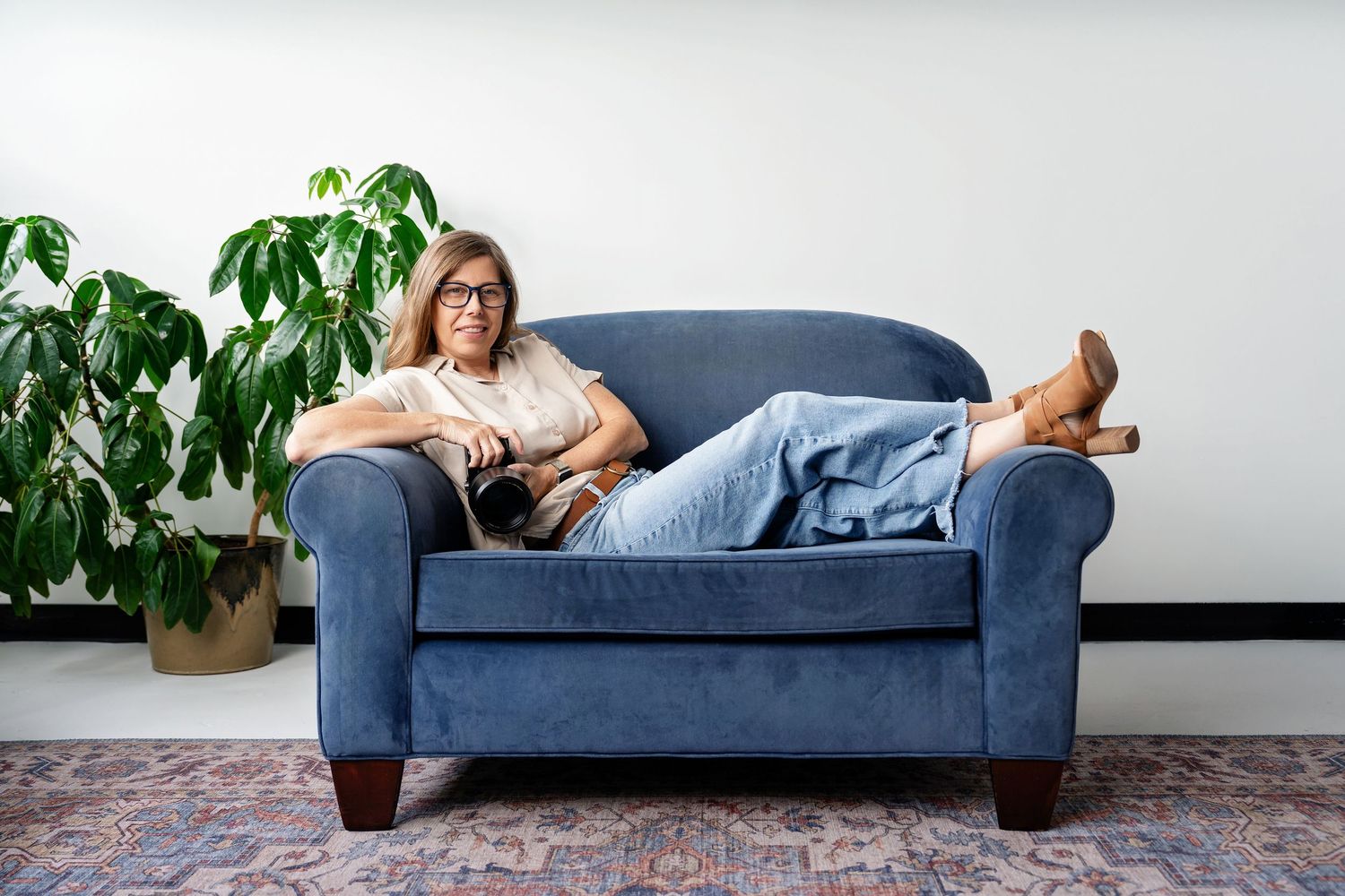 Milwaukee senior, family, headshot and branding photographer Rachel Dickman sitting in a blue chair with her feet up.