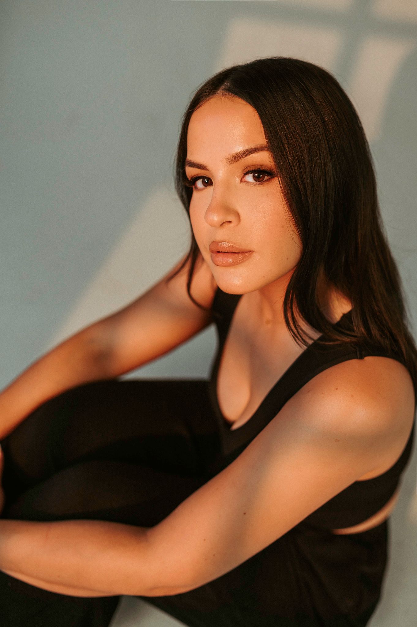 Artistic portrait series showing elegant poses in black clothing against a soft blurred background.
