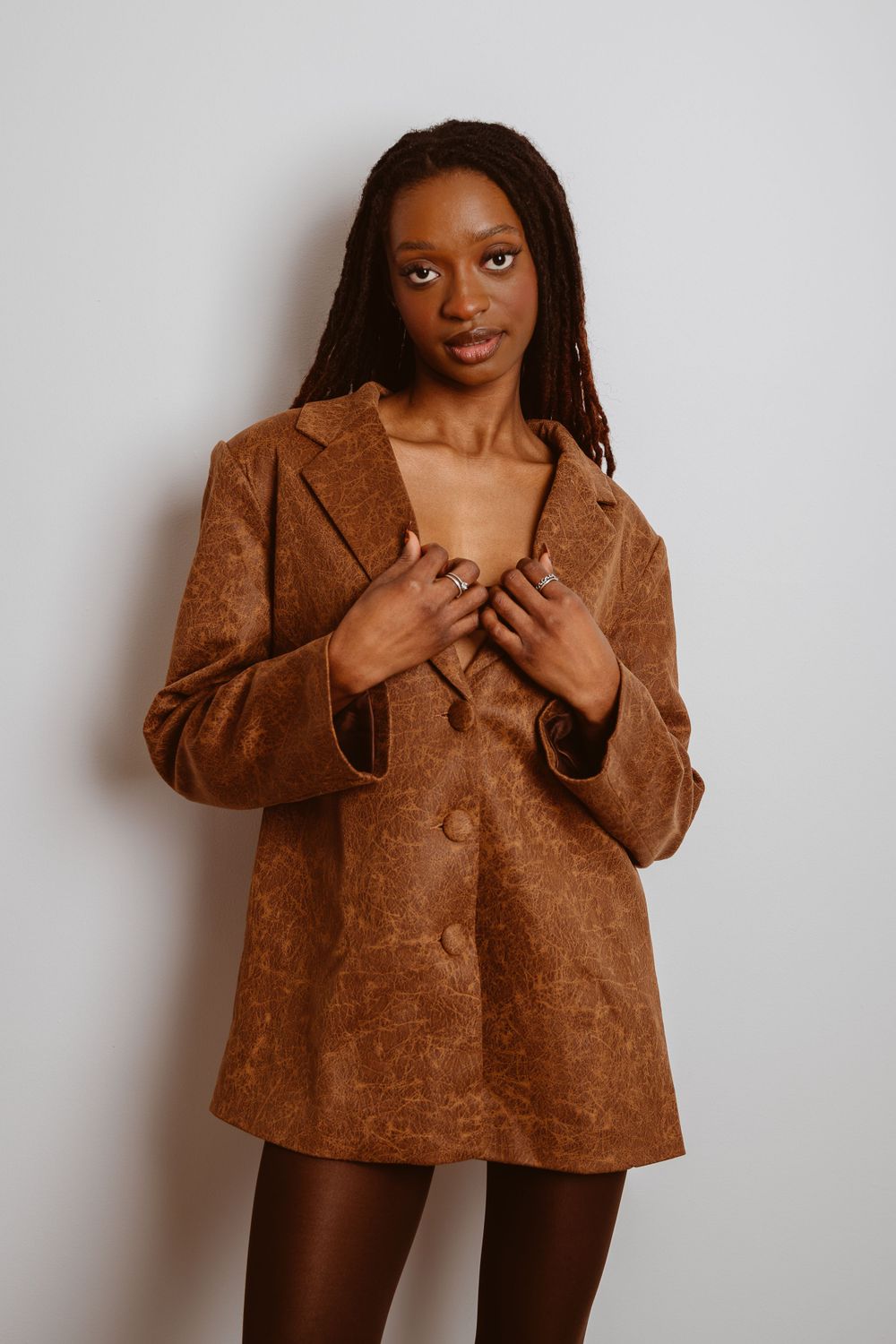 Stylish brown corduroy jacket shown in fashion photoshoot sequence against white backdrop.