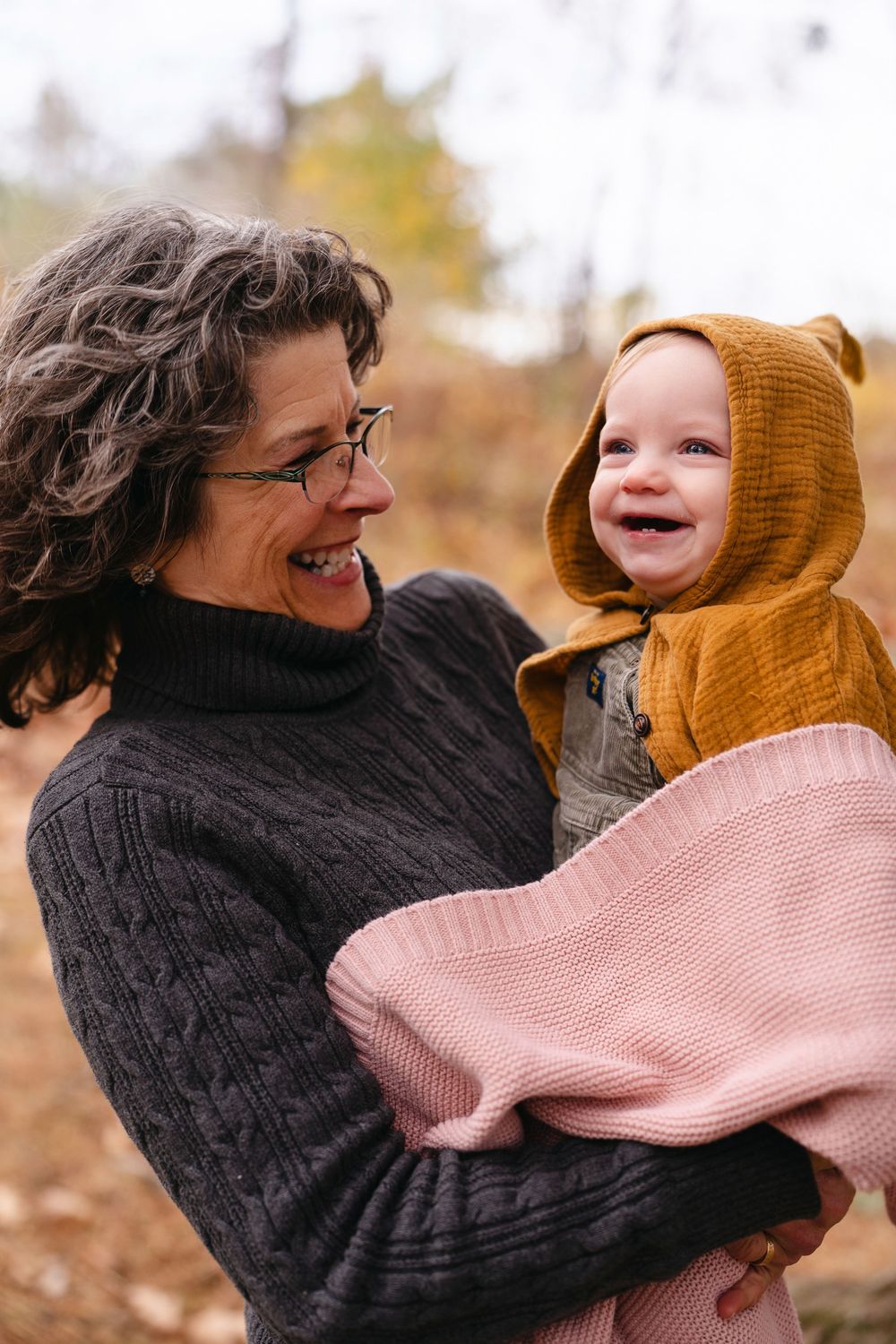 Candid shots of playful interaction between parent and child wearing knit sweaters outdoors in autumn.