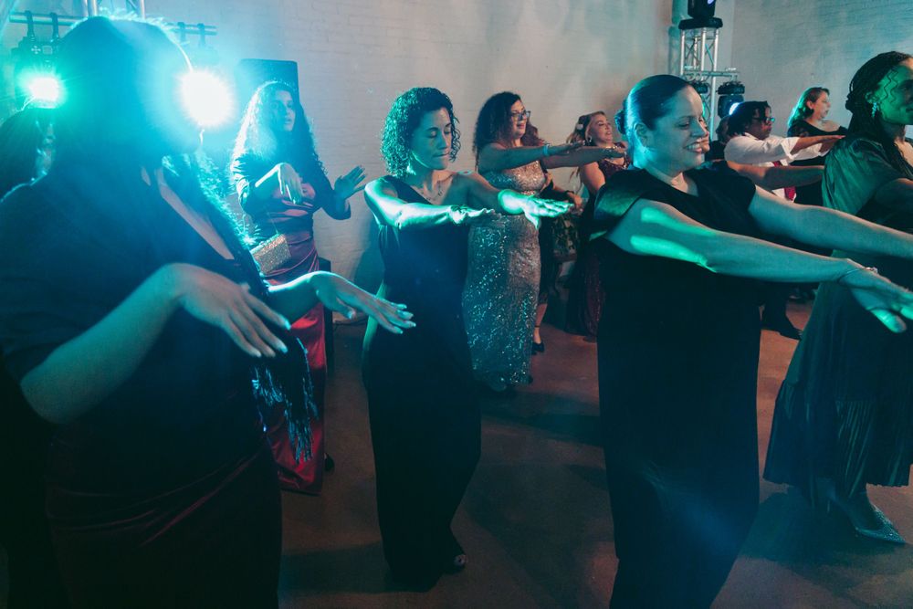 Wedding reception guests dancing in blue and purple lighting.