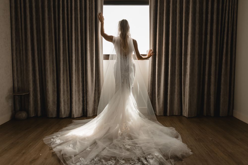editorial wedding and portrait photographer captures an elegant moody silhouette of a bride  showing the back and train of her wedding gown