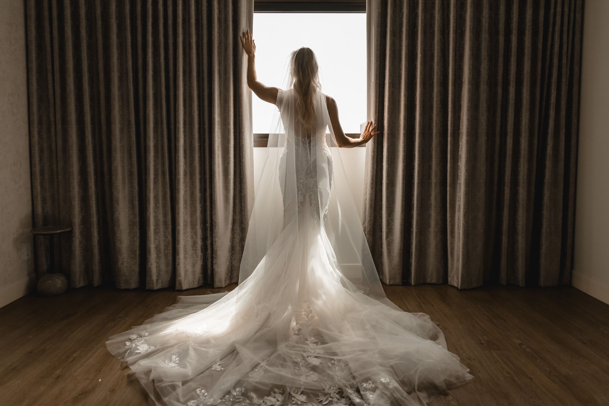 editorial wedding and portrait photographer captures an elegant moody silhouette of a bride  showing the back and train of her wedding gown