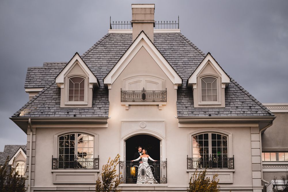 Panoramic view of luxury mansion exterior with wedding couple posing in the balcony at park chateau