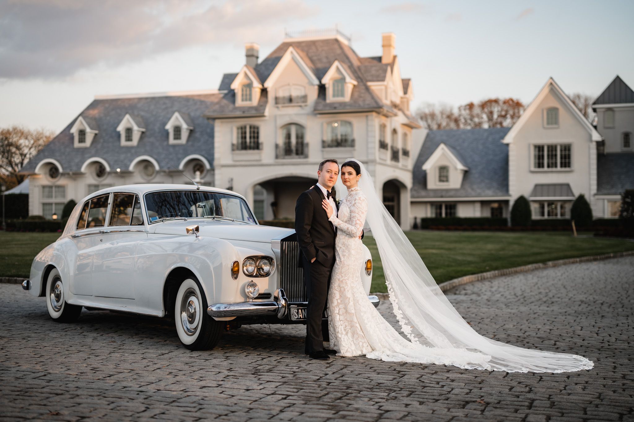Classic white vintage car parked in front of elegant park chateau