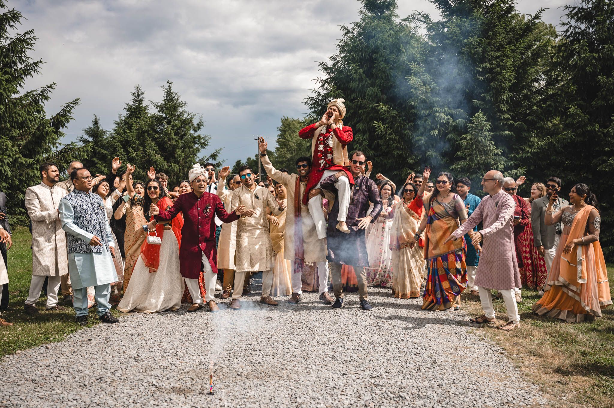 a south asian wedding tradition the groom is raised on the shoulders of his family as they dance toward the brides family