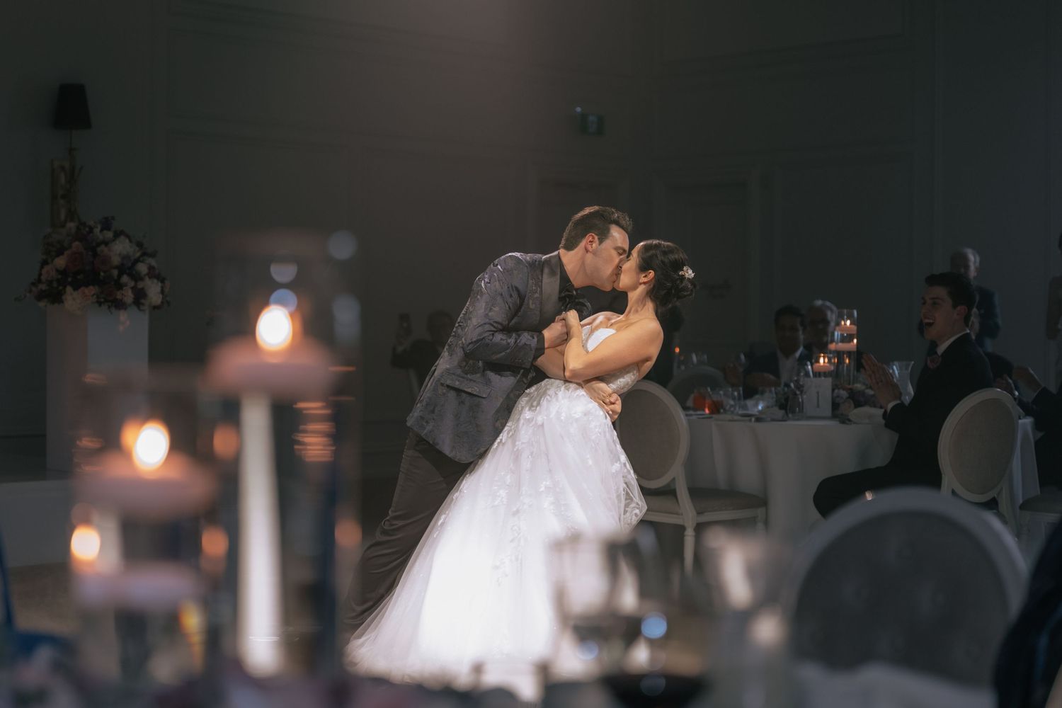 Bride and groom sharing a romantic moment in a golden elevator, dressed in wedding attire.