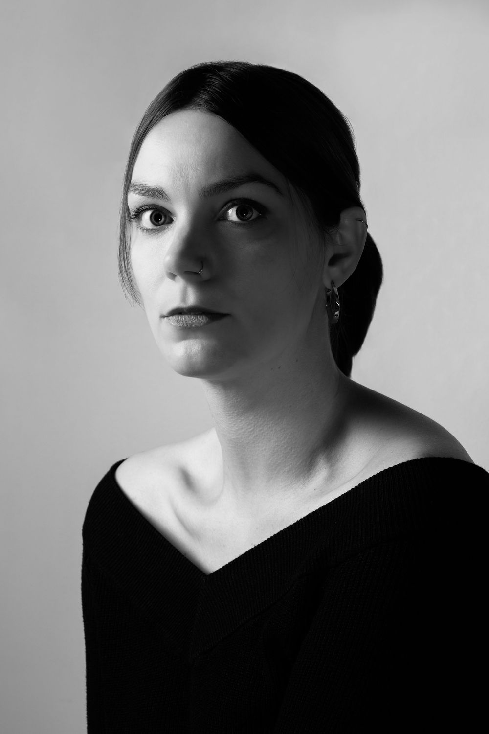 Portrait féminin en noir et blanc réalisé en lumière douce sur fond uni.