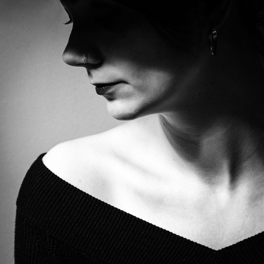 Portrait en noir et blanc mettant en valeur le profil d'une femme et les jeux d'ombre.
