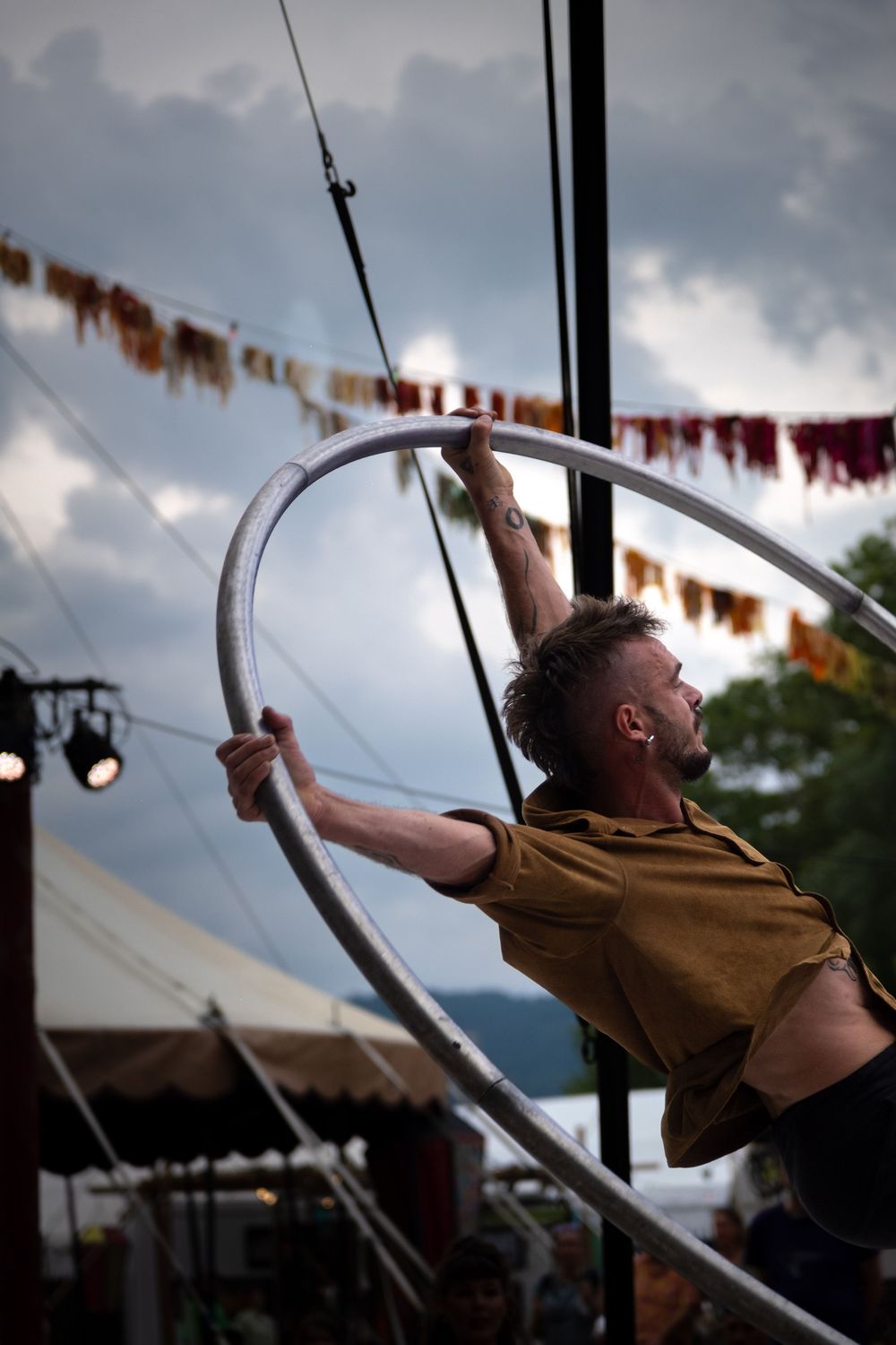 Acrobate réalisant une figure dans une roue Cyr lors d'un spectacle de cirque.