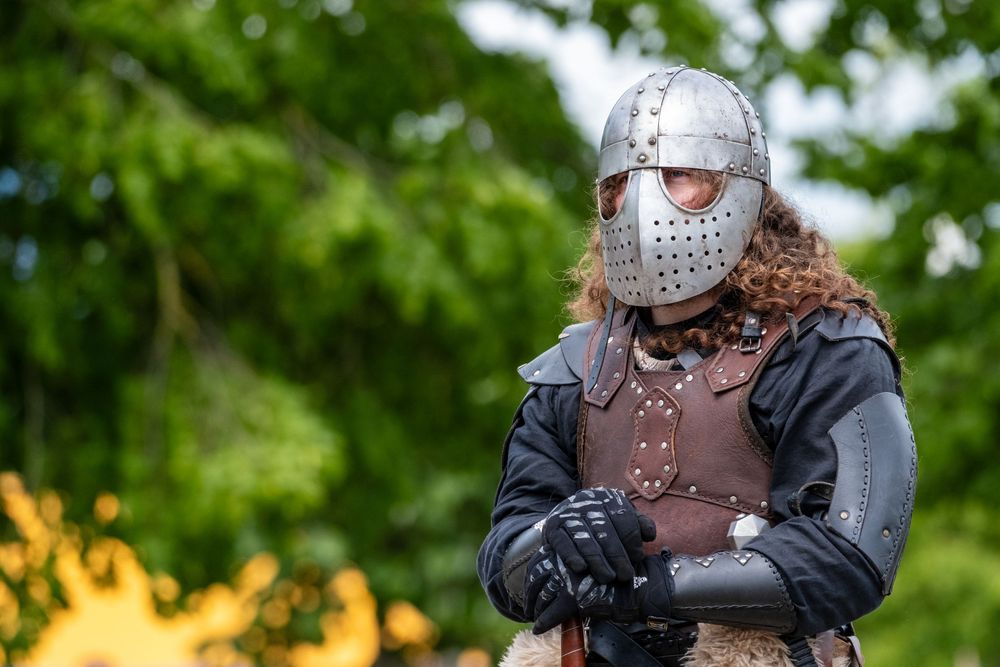 Guerrier en armure posant lors d'une reconstitution historique en plein air.