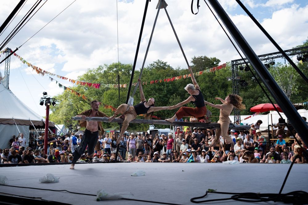 Troupe d'artistes de cirque réalisant une figure aérienne devant le public.