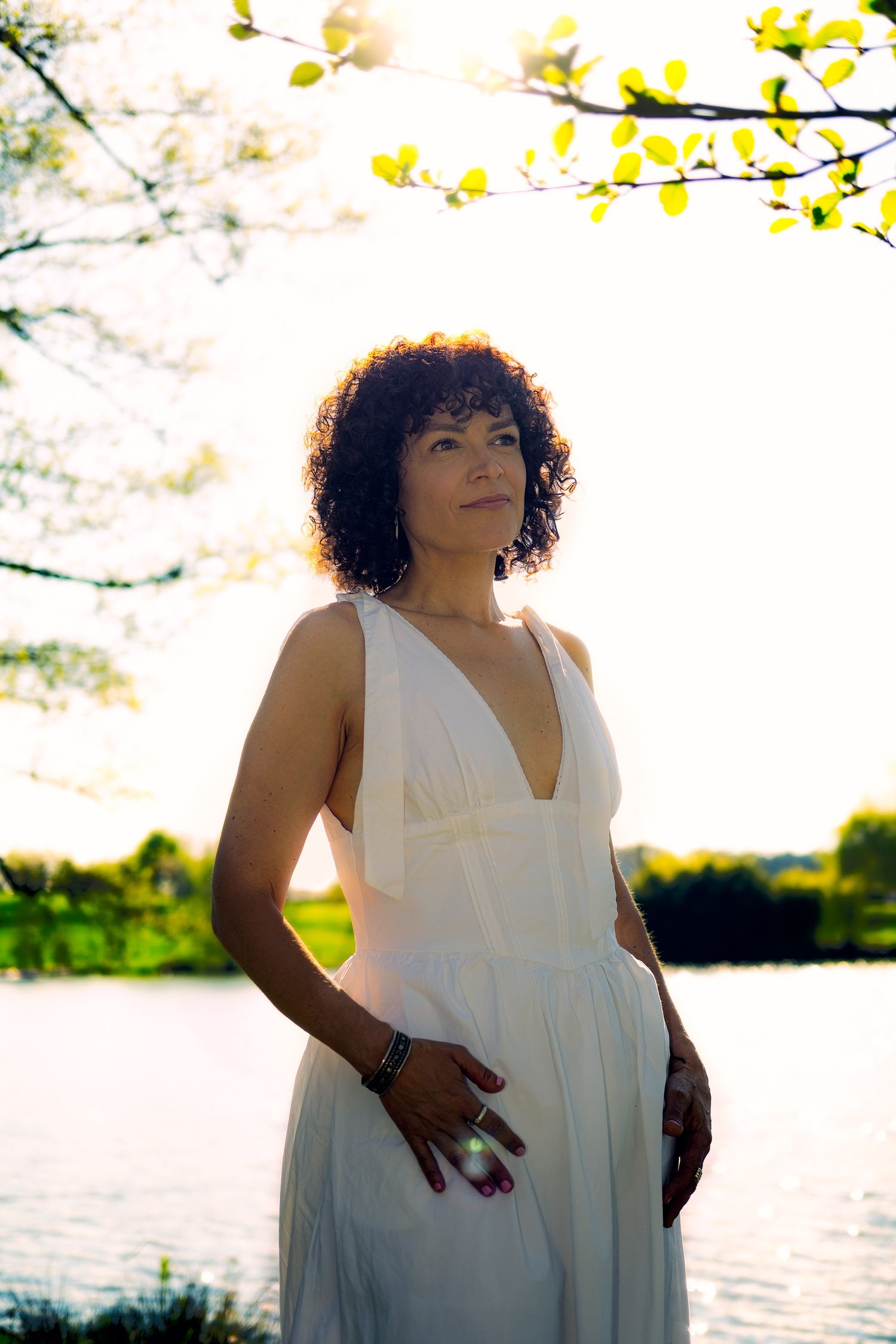 Portrait féminin en extérieur près de l'eau, baigné par une lumière de fin de journée.
