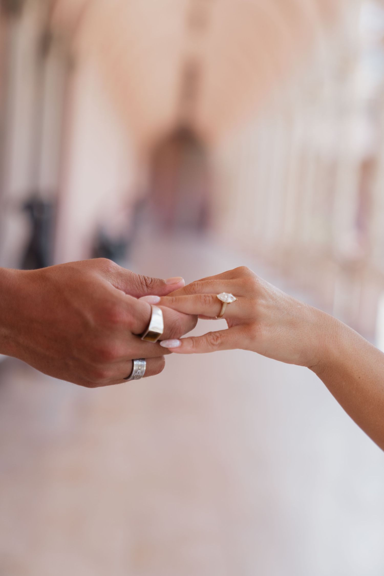Man proposing to woman in elegant arched colonnade of historic building with marble columns and courtyard.