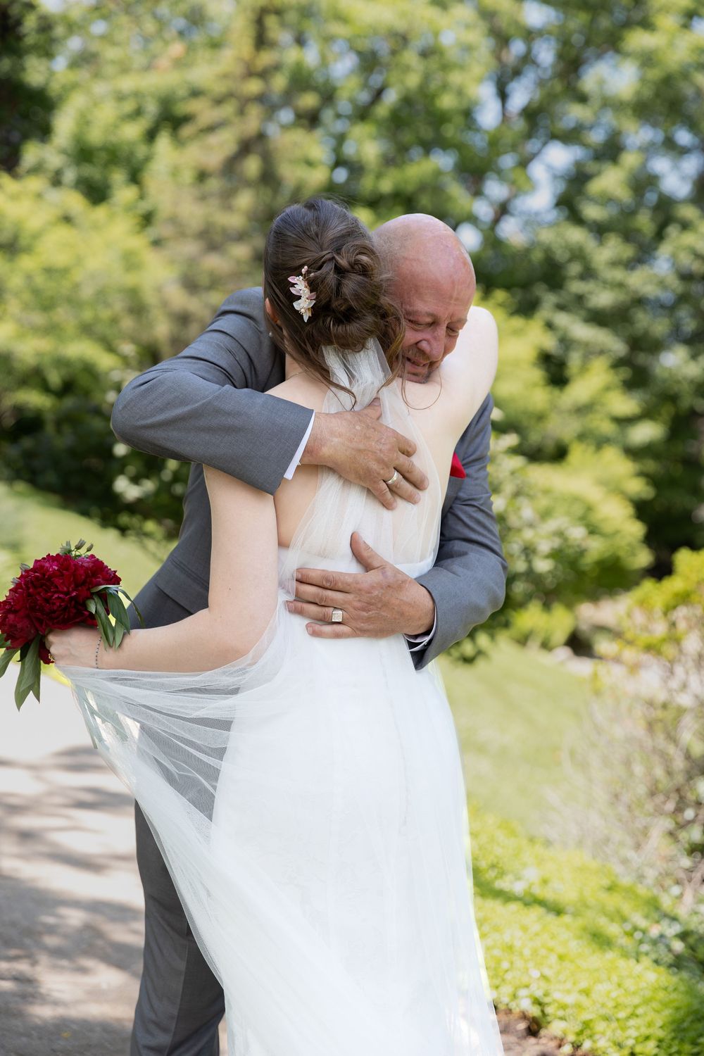 Bride and father share an emotional embrace during first look at their wedding at the civic garden complex in london, ontario