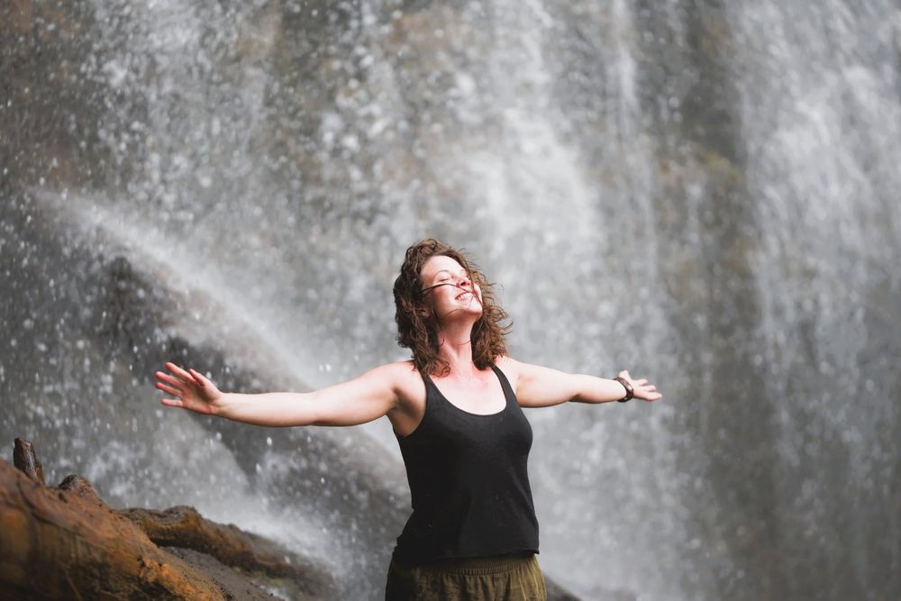 Stephanie Hudson standing beneath a waterfall