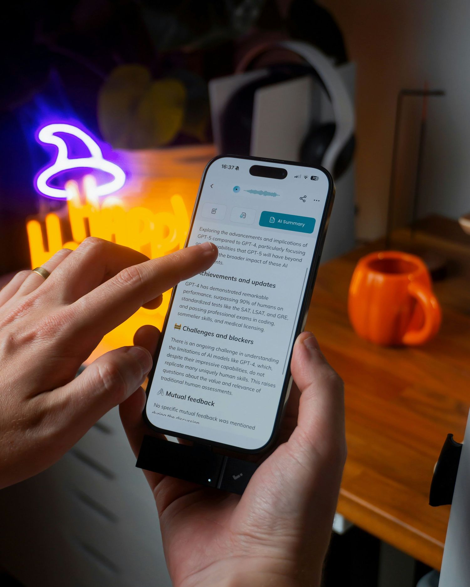 Hands holding a smartphone displaying a document app, with a glowing neon mushroom and orange mug in the background.