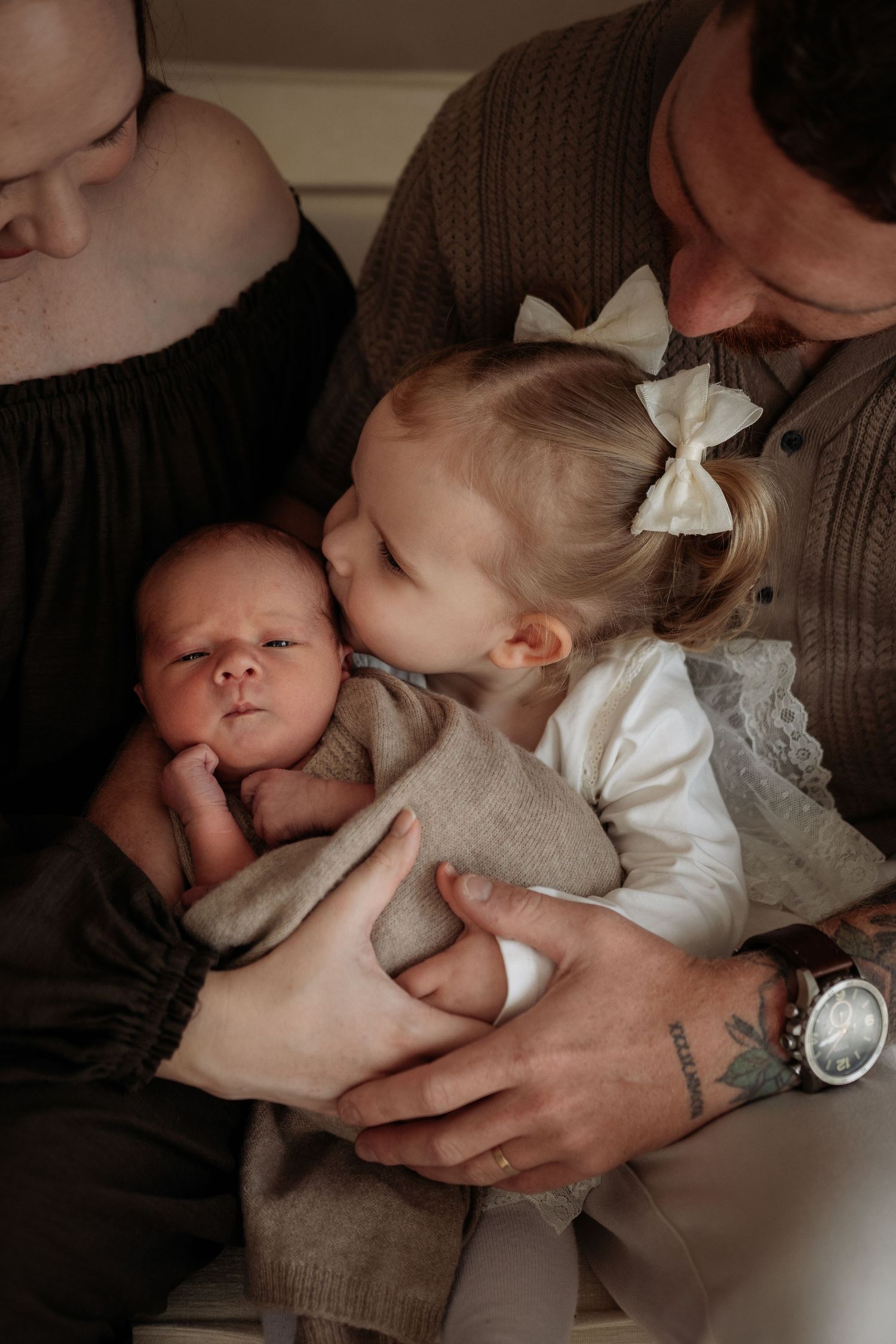 Toddler kissing newborn on cheek taken in Penrith Newborn Studio