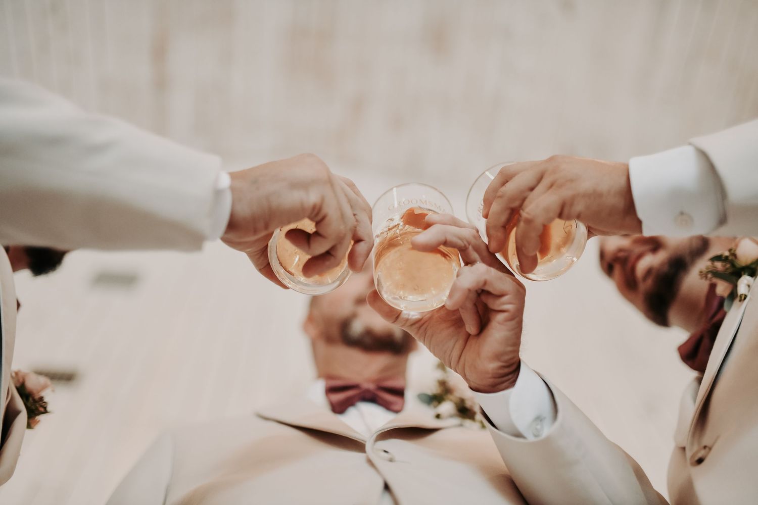 Fall groom style featuring an oatmeal-colored suit and mauve accessories
