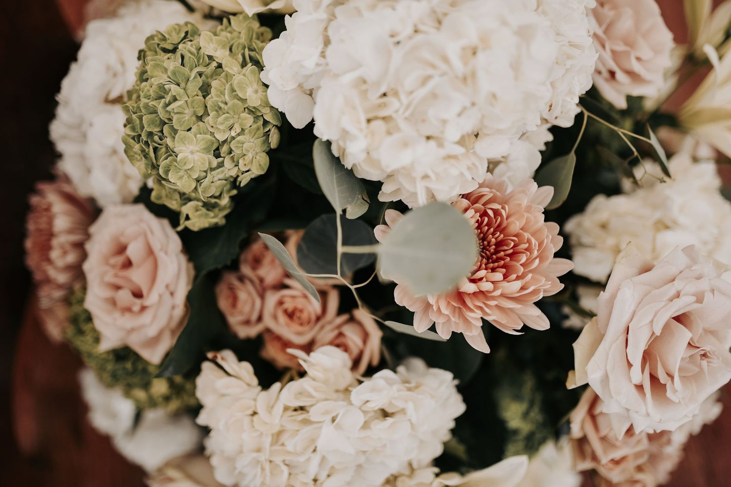 Large blush and ivory floral arrangements lining the aisle of The White Sparrow chapel