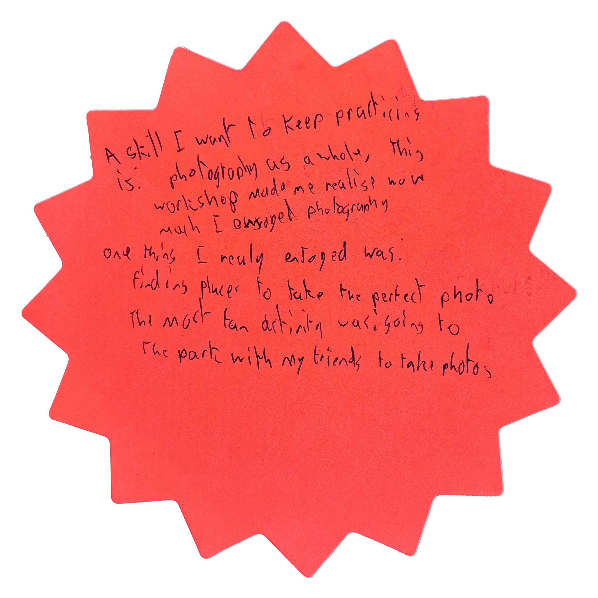 Handwritten note on a red starburst-shaped paper about a photography workshop, finding perfect photo spots, and taking photos with friends.