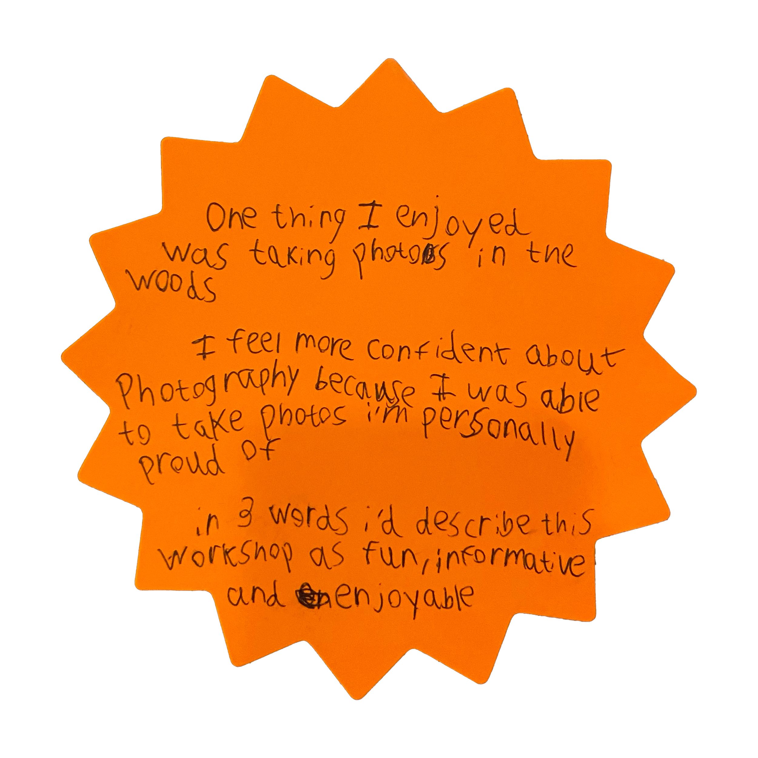 Orange starburst-shaped paper with handwritten workshop feedback about enjoying taking photos in the woods and feeling more confident in pho