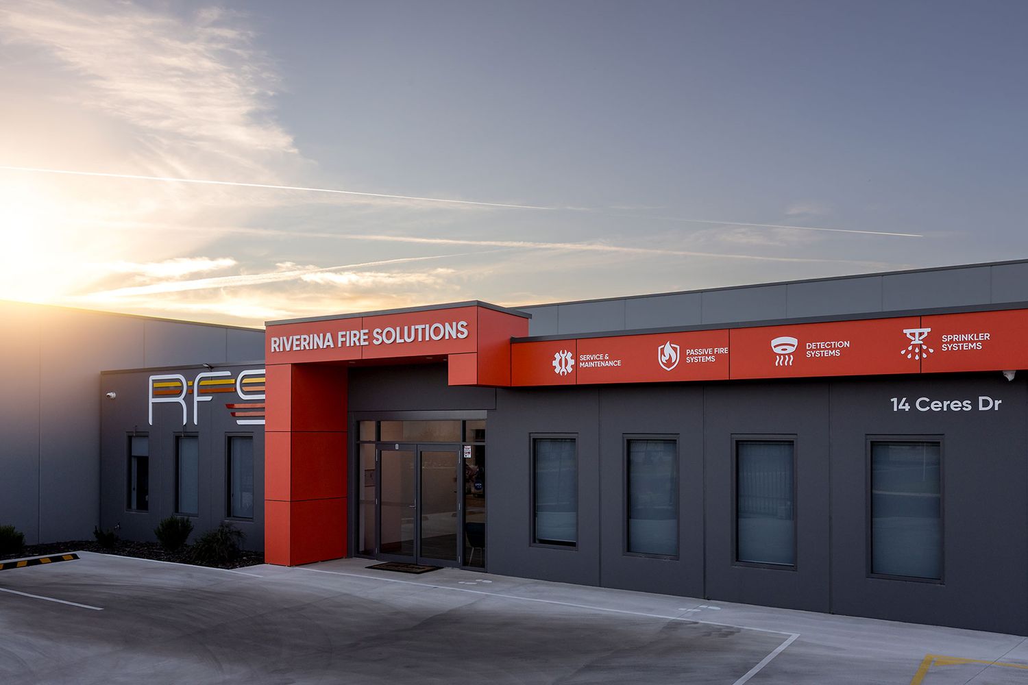 Riverina Fire Solutions building exterior at sunset, located at 14 Ceres Dr, featuring bold red and gray facade, photo by JRP Studio.