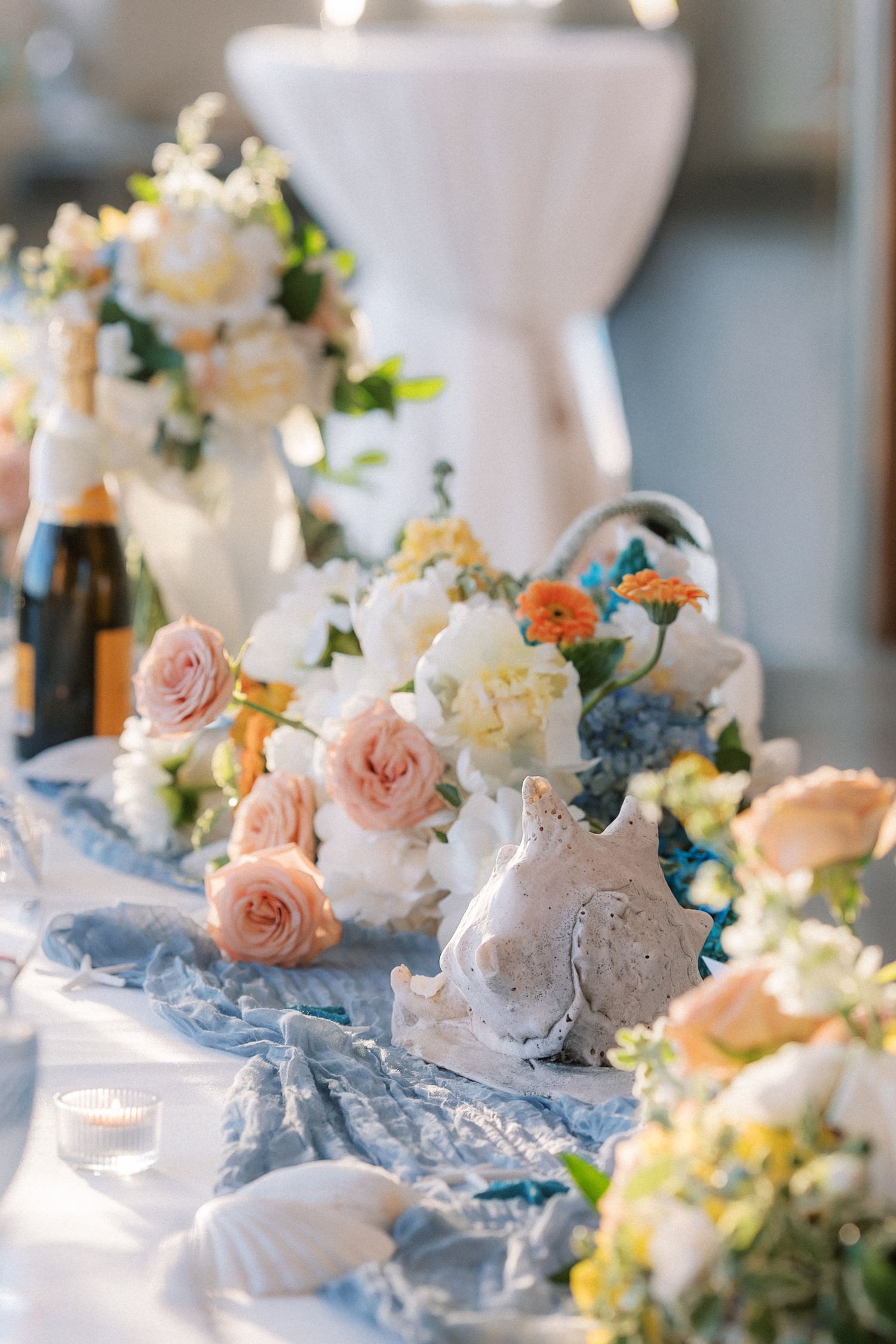 Elegant coastal-inspired wedding table decorated with pastel flowers, seashells and ocean-inspired styling at Arriba by the Sea.
