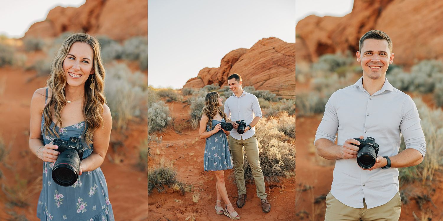 Couple photographers posing with cameras in red rock desert landscape, woman in floral dress and man in white shirt smiling.