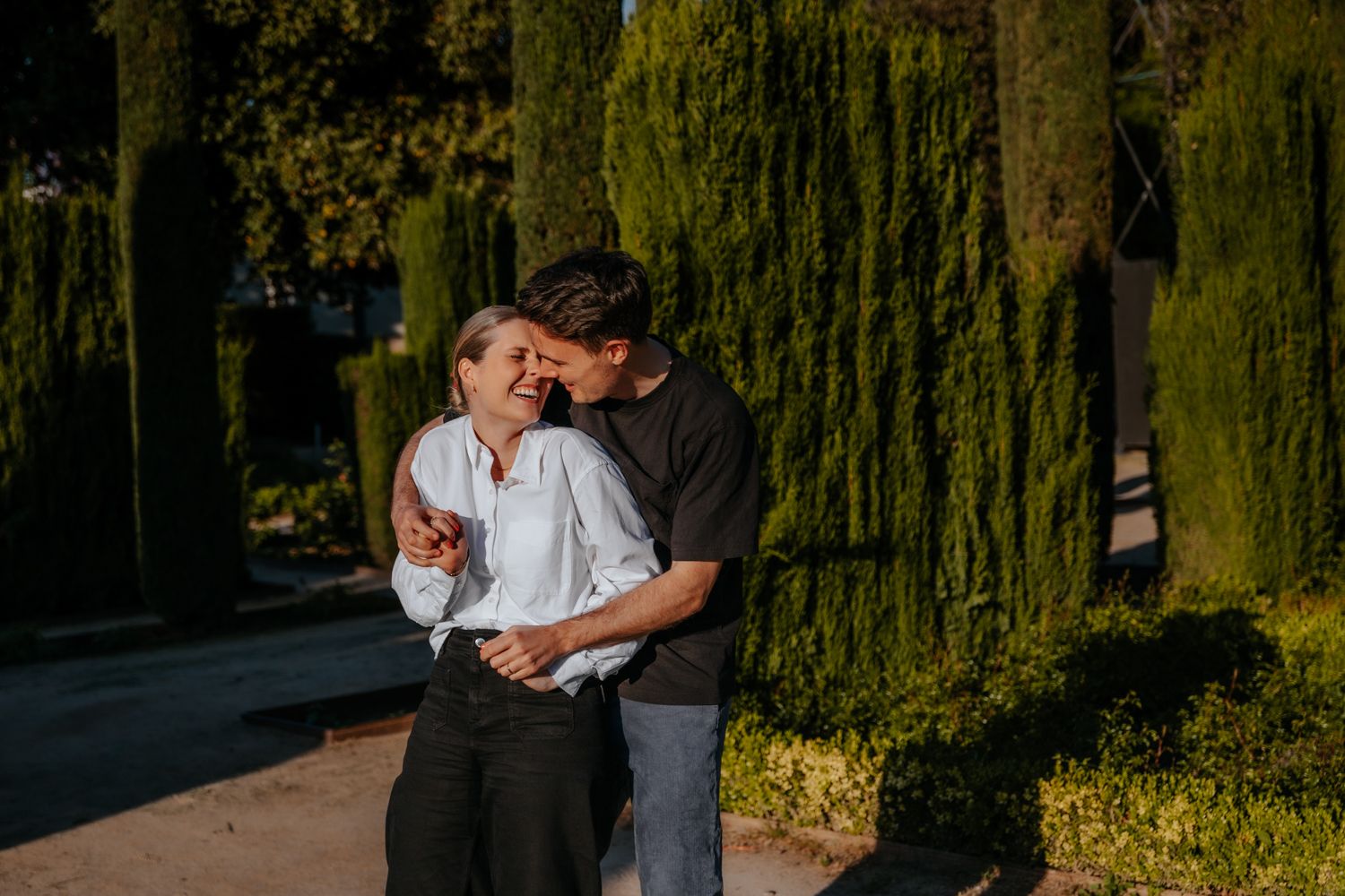 A couple sharing a quiet, intimate moment during their anniversary photoshoot on a scenic outdoor terrace surrounded by lush greenery.